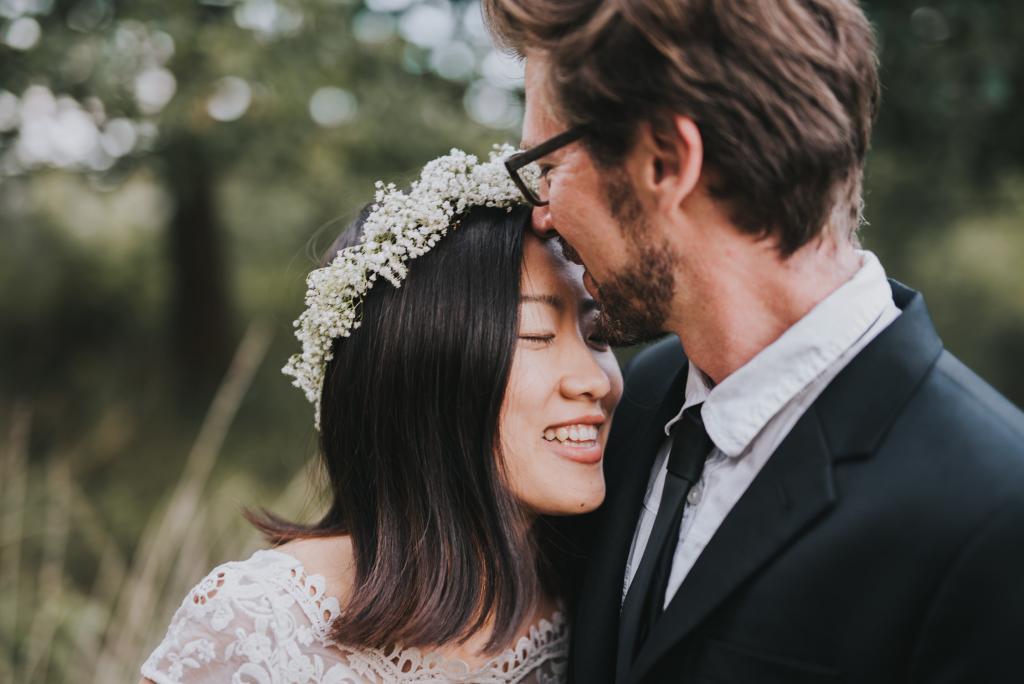 Bräutigam küsst die Braut auf die Stirn