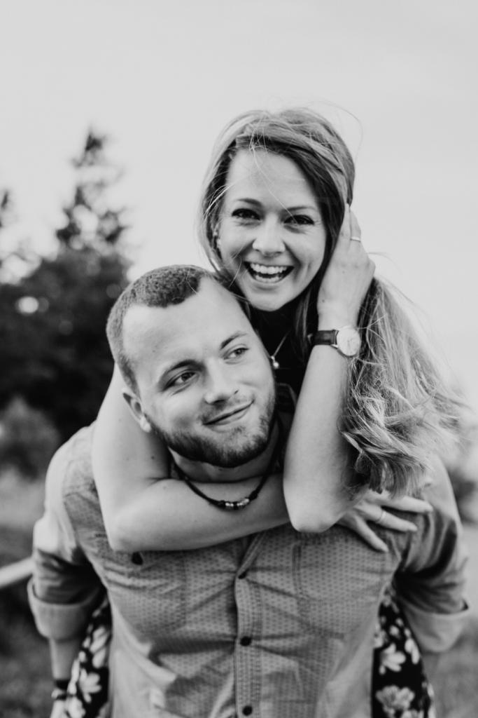 Lachende Frau auf Rücken des Freundes